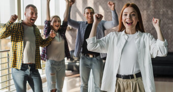 A group of friendly employees stand in an office 