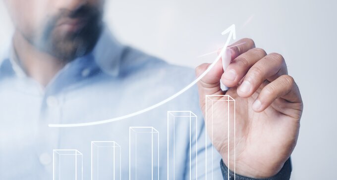 A man draws a graph showing success with a modern pen