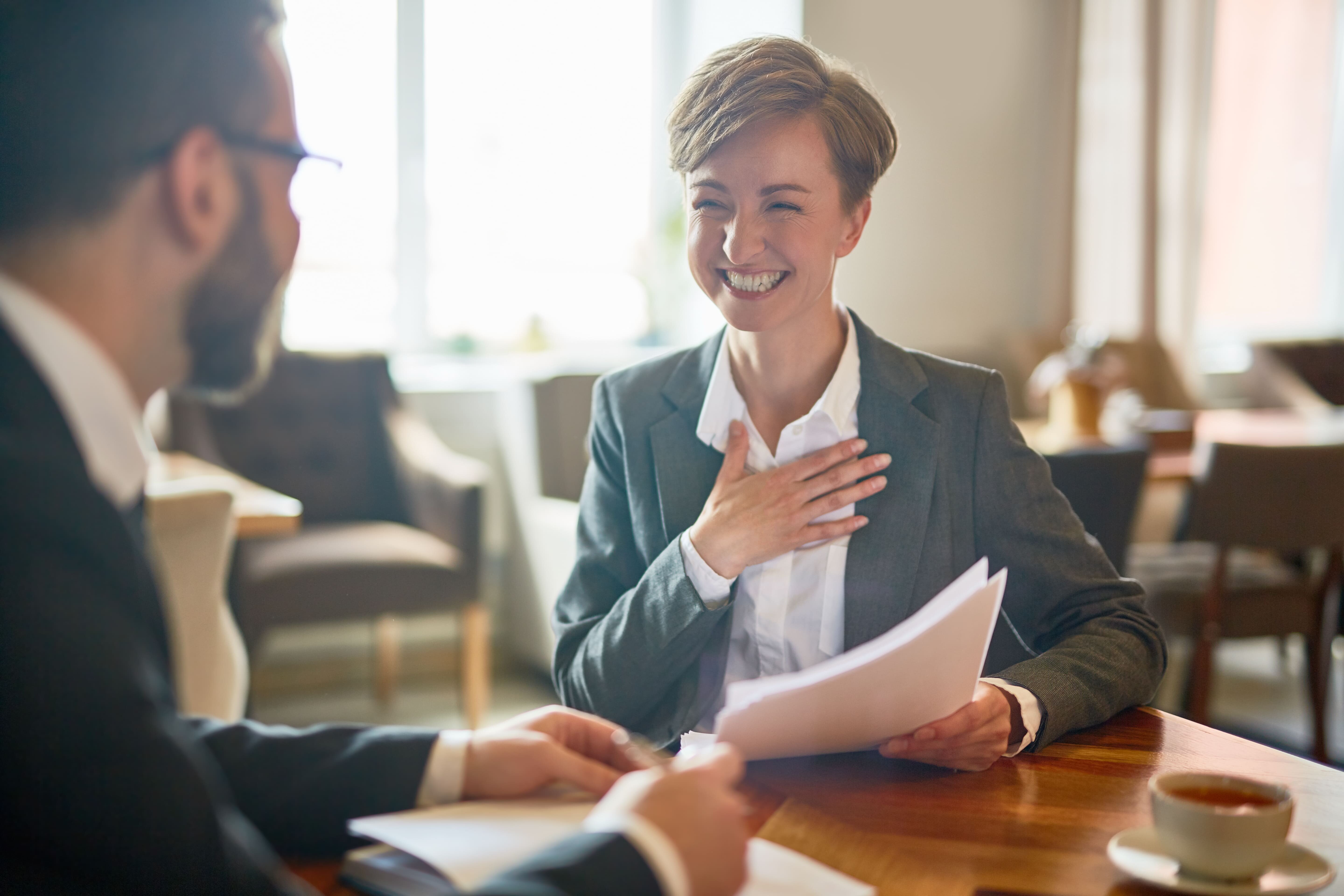 happy female employee with papers in hand is hired to work