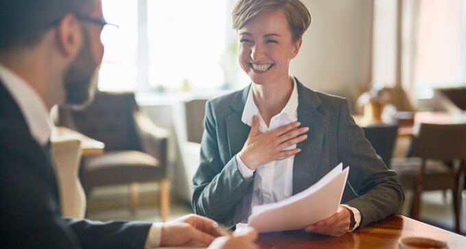 happy female employee with papers in hand is hired to work