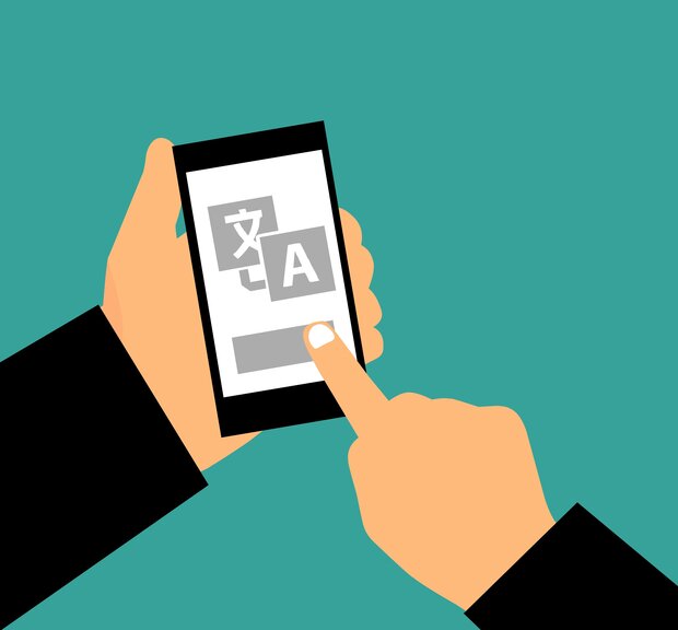Eine Person hält ein Smartphone, auf dem quicktranslate Modul angezeigt wird