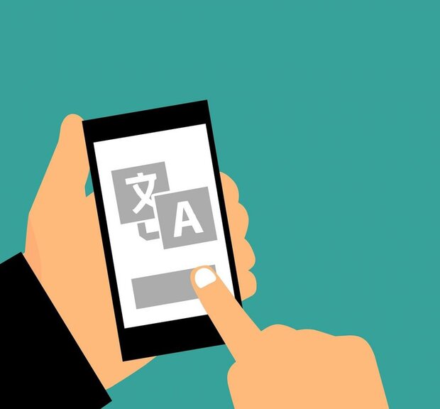 Eine Person hält ein Smartphone, auf dem quicktranslate XLIFF 2.0 Modul angezeigt wird